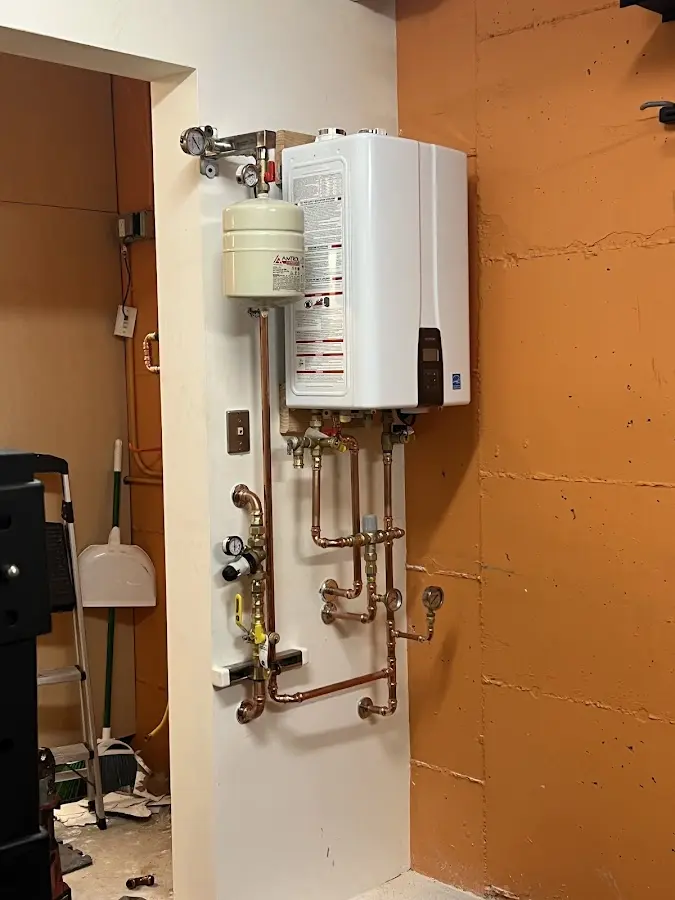 Plumbing technician inspecting water heater connections in Orangetree
